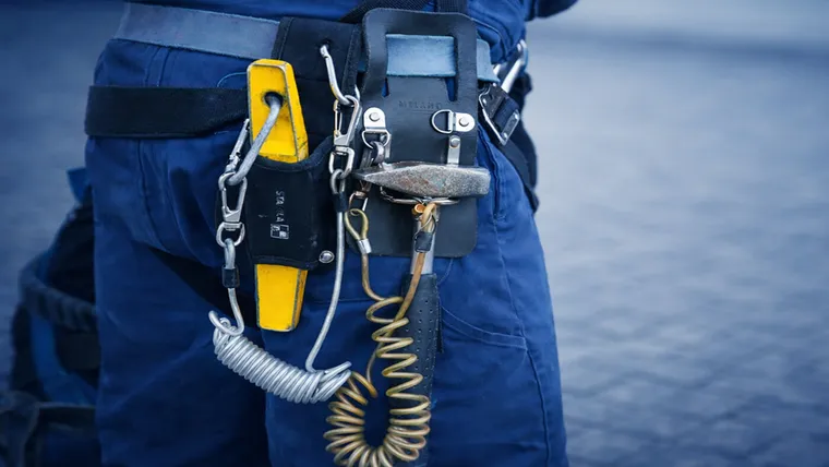 Technician inspecting harnesses and safety lines